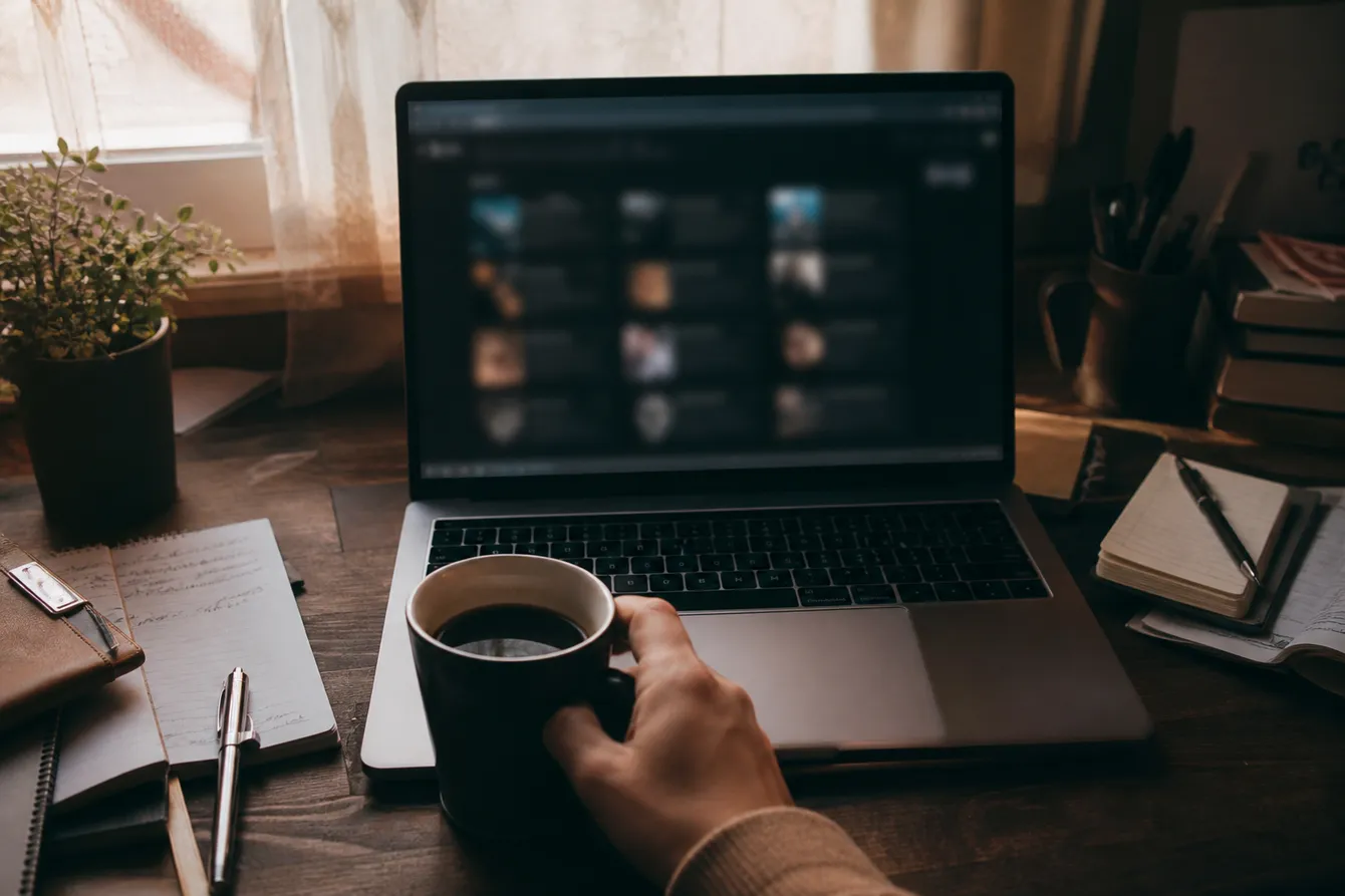 A laptop showing blurred dark web search results on a cluttered desk, hinting at safe exploration.
